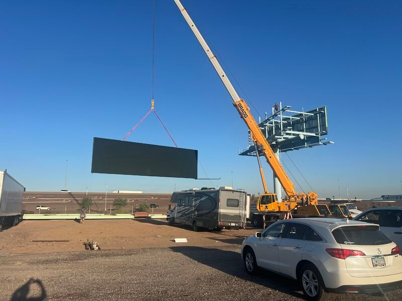 Crane setting a digital billboard face on a new freeway structure
